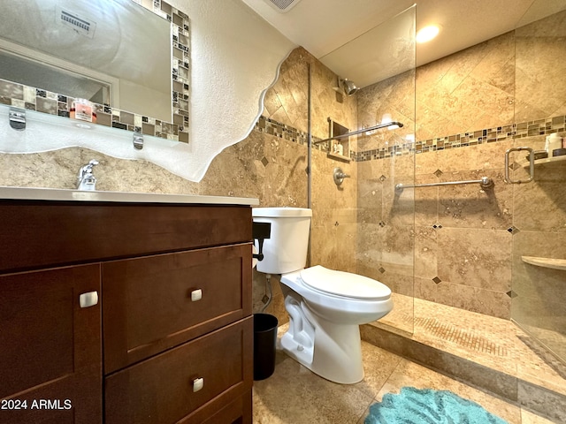 full bathroom with toilet, tiled shower, tile patterned floors, and vanity