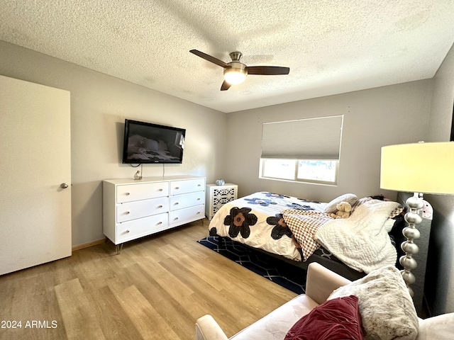 bedroom with a textured ceiling, wood finished floors, and ceiling fan