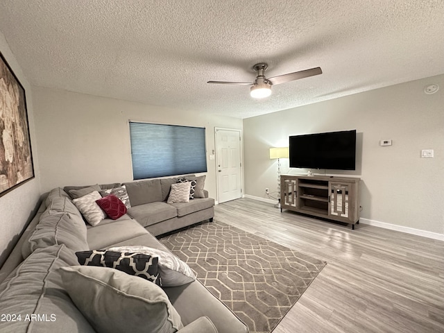 living room with a textured ceiling, wood finished floors, and a ceiling fan