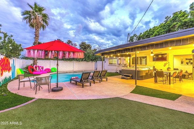 view of swimming pool with a patio, a yard, and a hot tub