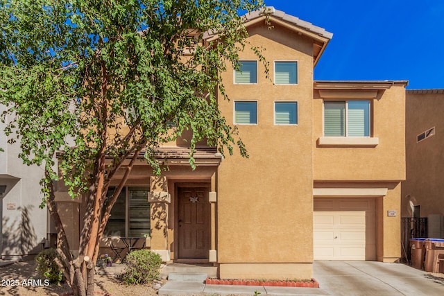 view of front of home featuring an attached garage, driveway, and stucco siding