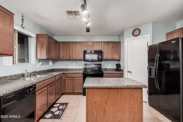 kitchen with light tile patterned floors, a kitchen island, a sink, visible vents, and black appliances