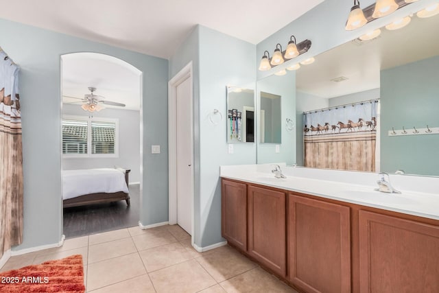 bathroom with a ceiling fan, tile patterned flooring, a sink, and double vanity