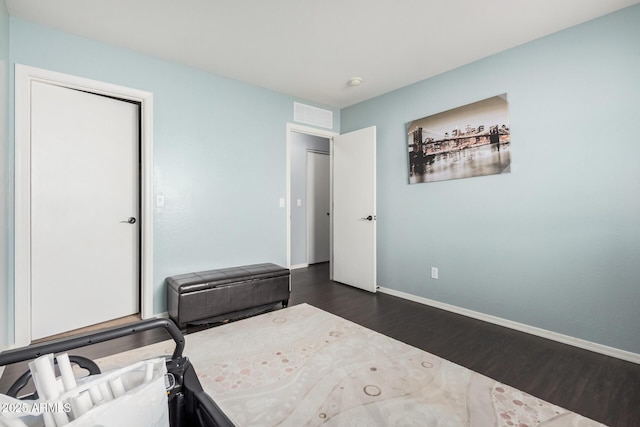 unfurnished bedroom with baseboards, visible vents, and dark wood-type flooring