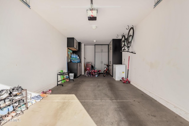 garage with a garage door opener and baseboards