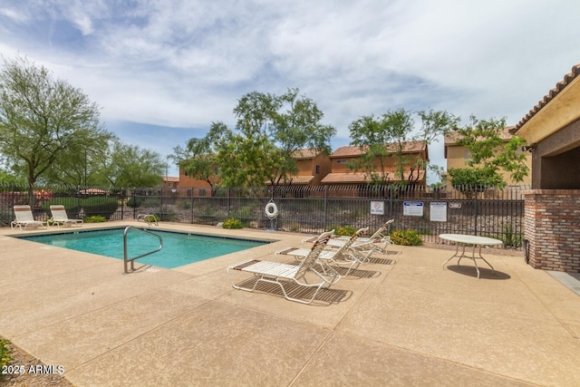 community pool featuring fence and a patio