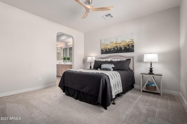 carpeted bedroom featuring ceiling fan and ensuite bath