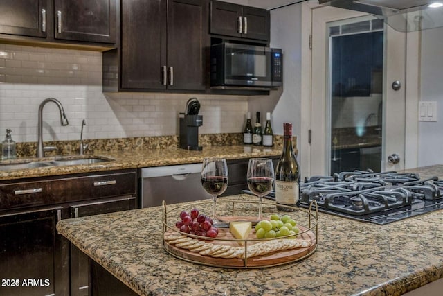 kitchen featuring decorative backsplash, appliances with stainless steel finishes, dark brown cabinetry, and sink