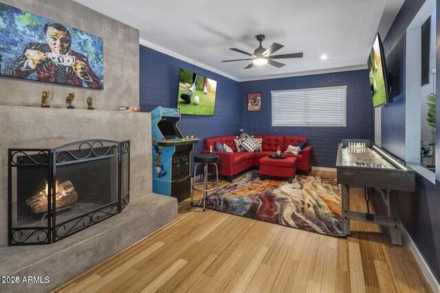 living room featuring hardwood / wood-style flooring, ceiling fan, and ornamental molding