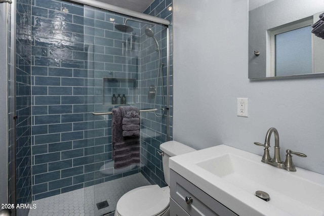 bathroom with vanity, toilet, and a shower with shower door