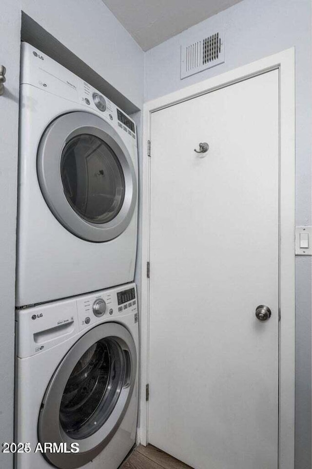 clothes washing area with stacked washer and clothes dryer