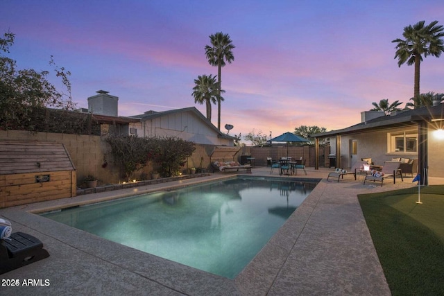 pool at dusk with a patio