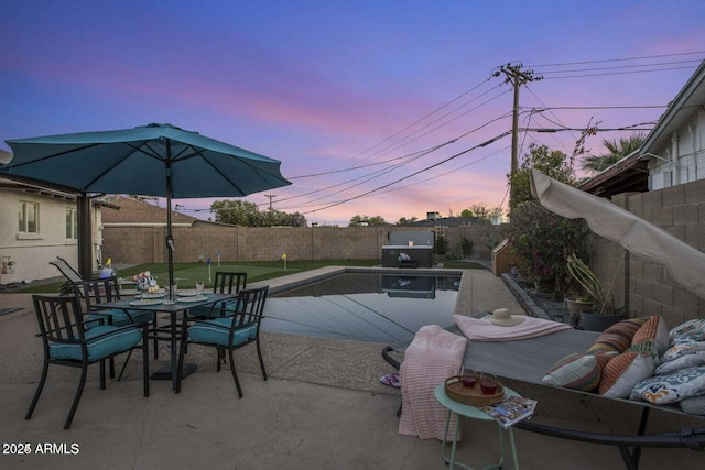 pool at dusk with a patio area