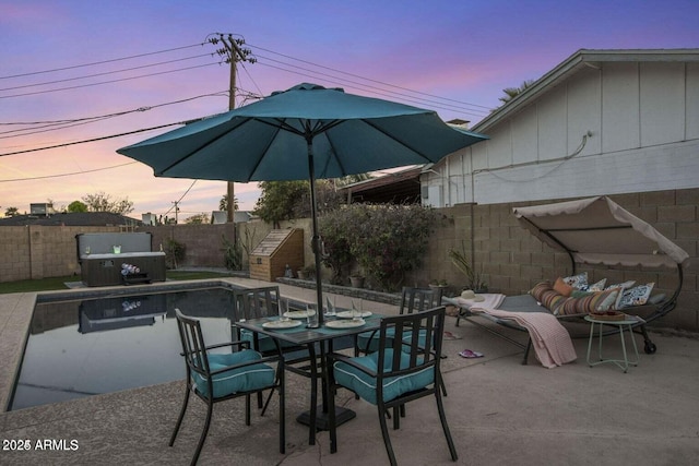 patio terrace at dusk featuring area for grilling and a hot tub