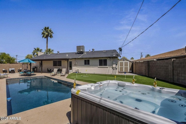 view of swimming pool with central AC, a patio, and a hot tub