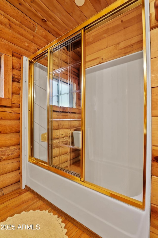 1868 Flicker Dr, Forest Lakes, AZ 85931 - bathroom featuring log walls, bath / shower combo with glass door, and wood finished floors