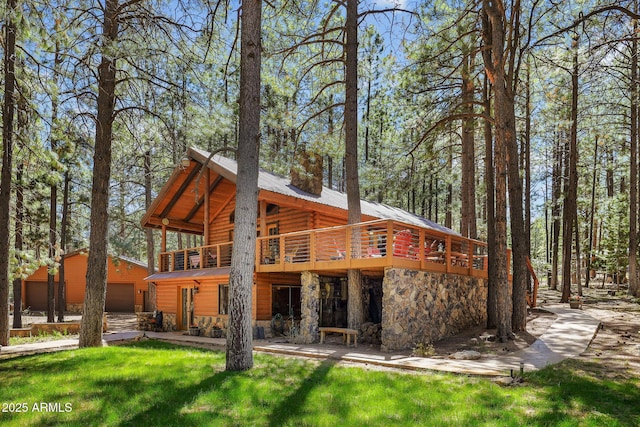 1868 Flicker Dr, Forest Lakes, AZ 85931 - rear view of house featuring an outdoor structure, a deck, a garage, stone siding, and a lawn