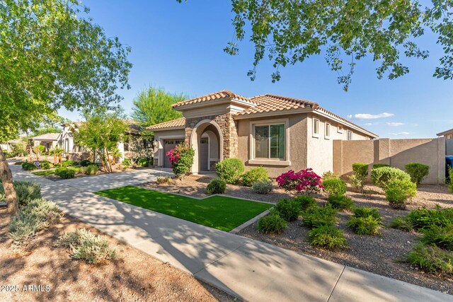 20783 W Pasadena Ave, Buckeye, AZ 85396 - mediterranean / spanish home featuring stucco siding, a tiled roof, driveway, and a garage