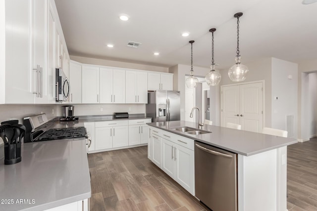 20783 W Pasadena Ave, Buckeye, AZ 85396 - kitchen with stainless steel appliances, a sink, light wood finished floors, white cabinets, and recessed lighting