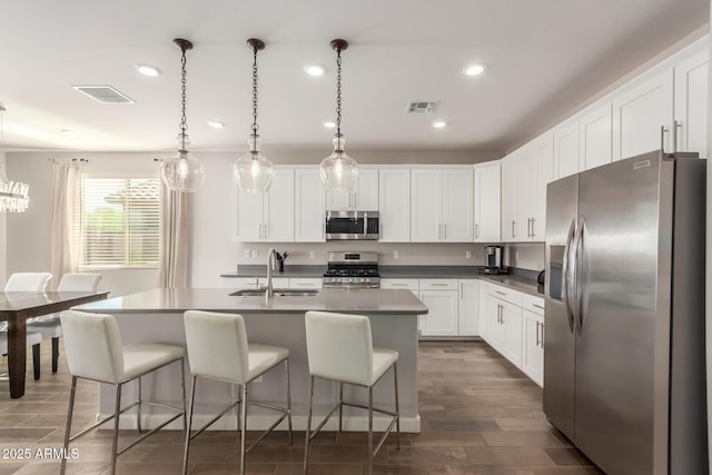 20783 W Pasadena Ave, Buckeye, AZ 85396 - kitchen with stainless steel appliances, a sink, recessed lighting, a kitchen bar, and white cabinetry