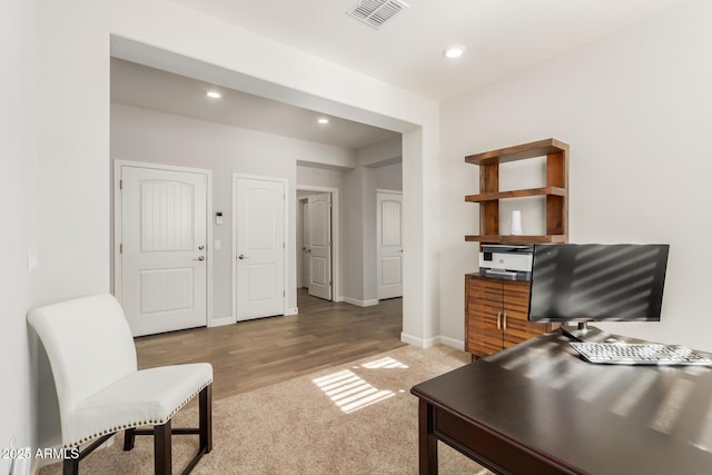 20783 W Pasadena Ave, Buckeye, AZ 85396 - home office featuring recessed lighting, baseboards, light carpet, and light wood finished floors