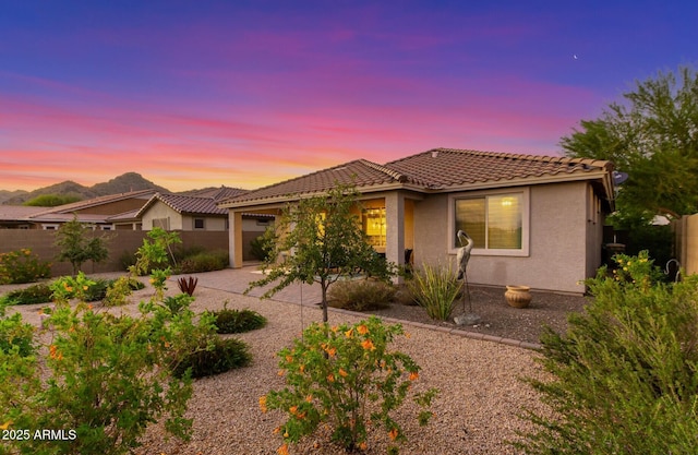 20783 W Pasadena Ave, Buckeye, AZ 85396 - view of front of house with stucco siding, a fenced backyard, a tiled roof, a patio area, and an attached garage