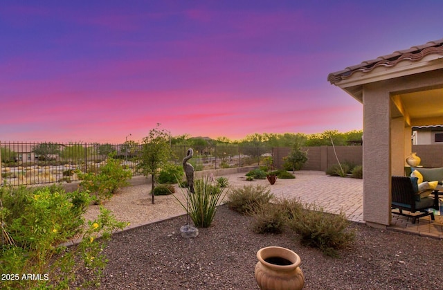 20783 W Pasadena Ave, Buckeye, AZ 85396 - yard at dusk with a patio area and a fenced backyard