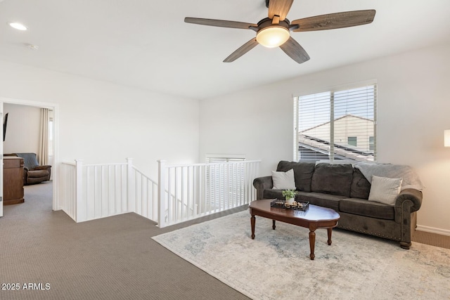 carpeted living area with ceiling fan