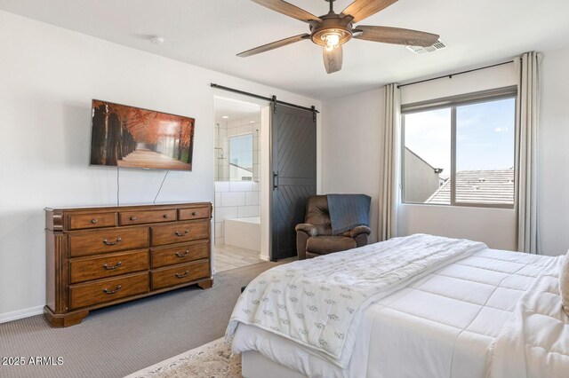 bedroom with a barn door, light colored carpet, ceiling fan, and connected bathroom