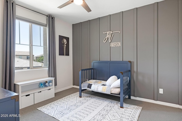 sitting room featuring carpet floors, plenty of natural light, a ceiling fan, a decorative wall, and baseboards