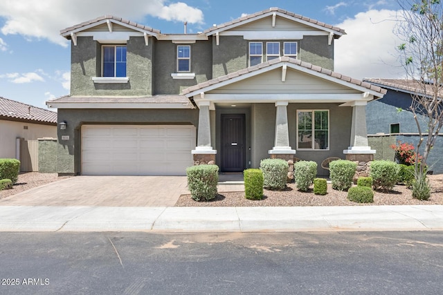craftsman house with a tile roof, decorative driveway, and stucco siding