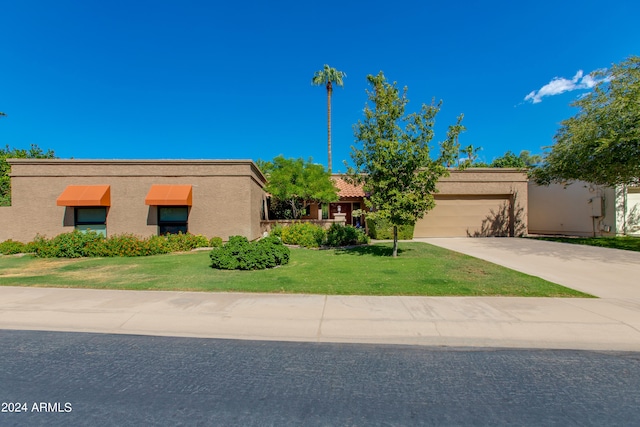 view of front of home with a garage and a front lawn