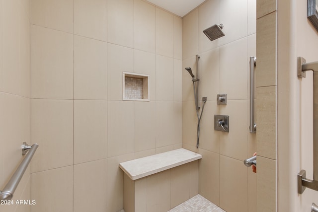 bathroom with a tile shower and tile walls