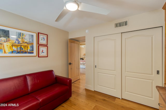 living room with light hardwood / wood-style floors and ceiling fan