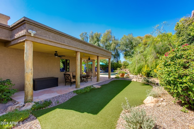 view of yard featuring ceiling fan and a patio