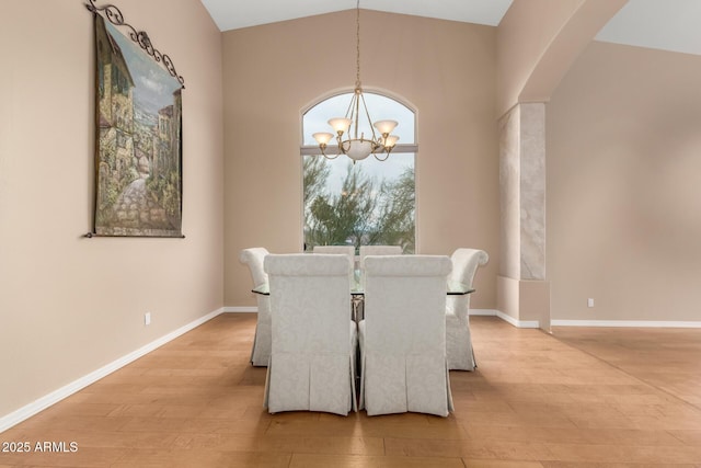 dining space with vaulted ceiling, a chandelier, and light hardwood / wood-style flooring