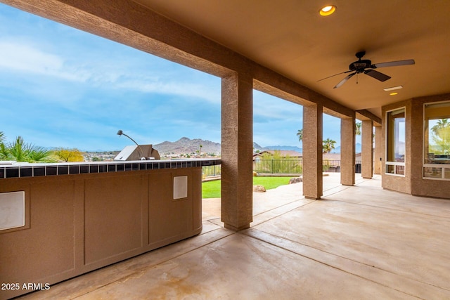 view of patio / terrace with a mountain view and ceiling fan