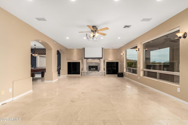 unfurnished living room with ceiling fan and a high end fireplace