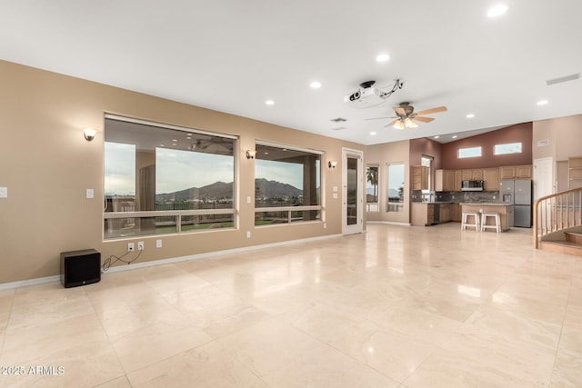 unfurnished living room with ceiling fan and a healthy amount of sunlight