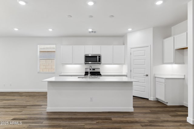 kitchen featuring white cabinetry, sink, and an island with sink