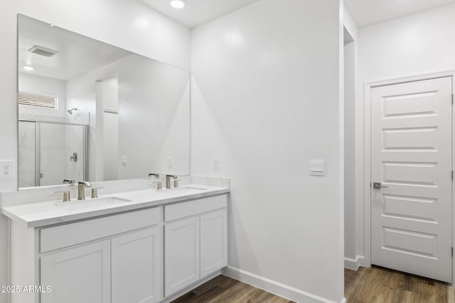 bathroom with vanity, hardwood / wood-style floors, and a shower with shower door