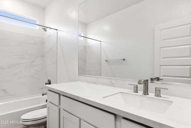 full bathroom featuring tiled shower / bath combo, vanity, and toilet