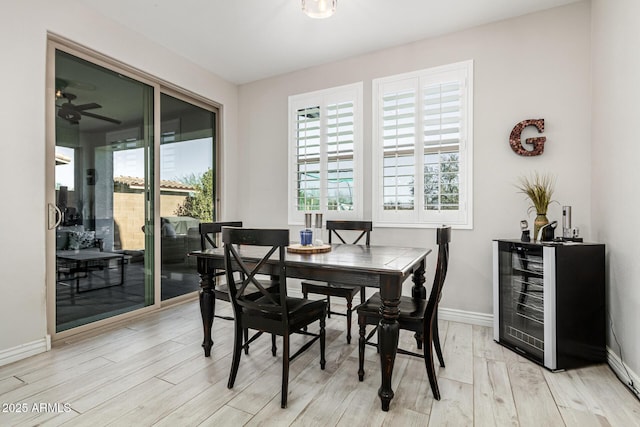 dining space featuring wine cooler, plenty of natural light, and light hardwood / wood-style flooring