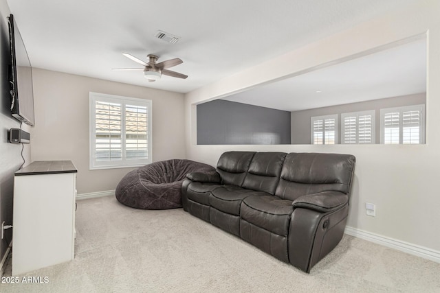 carpeted living room with ceiling fan