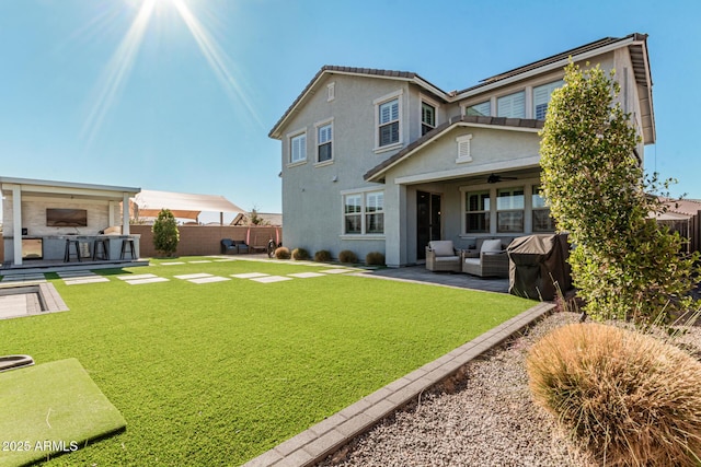 back of house featuring a yard, an outdoor bar, ceiling fan, an outdoor living space, and a patio area