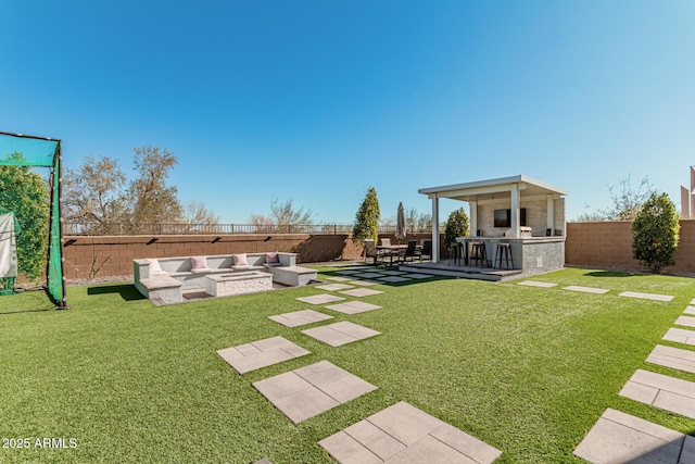 view of yard with exterior kitchen, a patio, an outdoor fire pit, and a bar