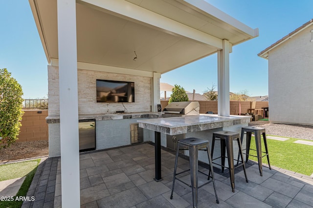 view of patio with a grill, exterior bar, and exterior kitchen