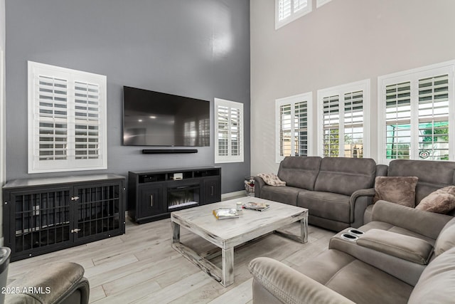 living room with a high ceiling and light wood-type flooring