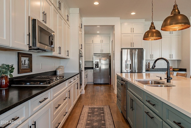 kitchen with stainless steel appliances, dark wood-style flooring, a sink, and white cabinets