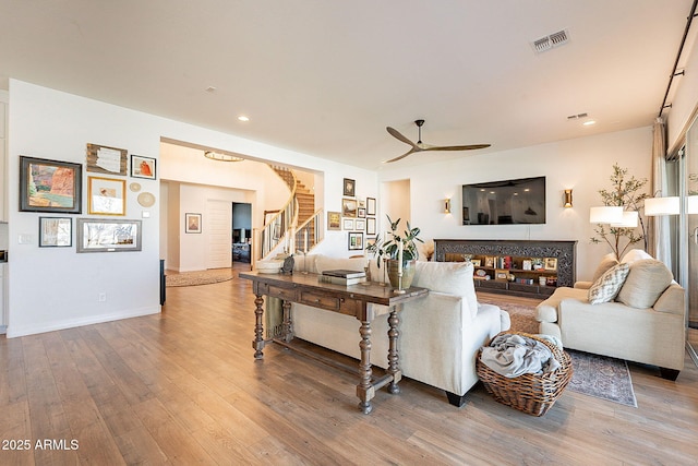 living area with visible vents, a ceiling fan, wood finished floors, stairs, and recessed lighting